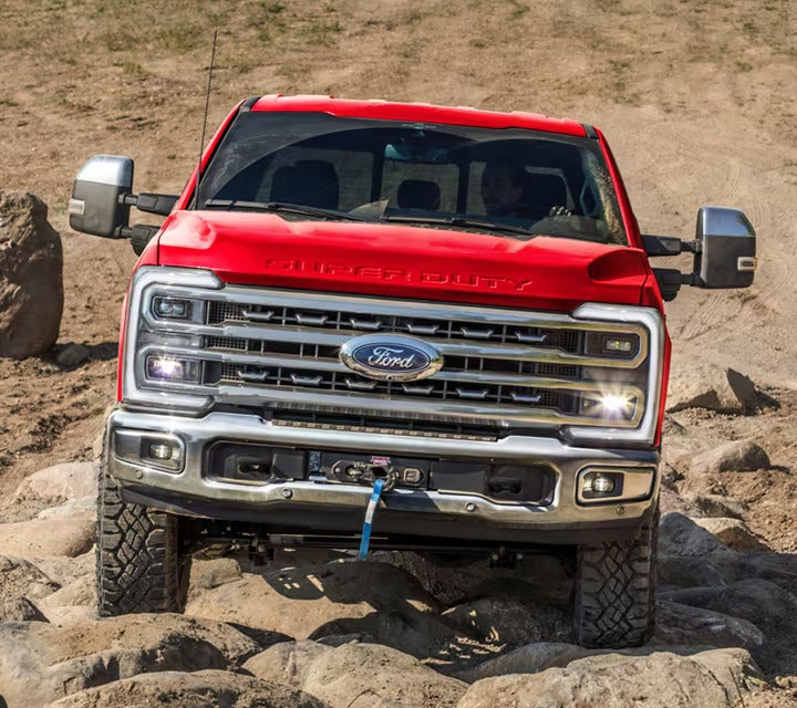An upclose view of the front of a red ford truck.