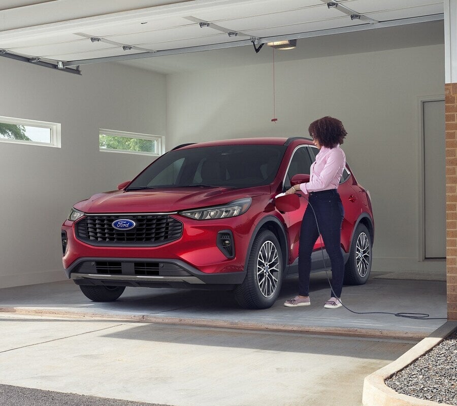 2025 Ford Escape Plug-In Hybrid being charged in a garage, showcasing its plug-in hybrid capabilities.
