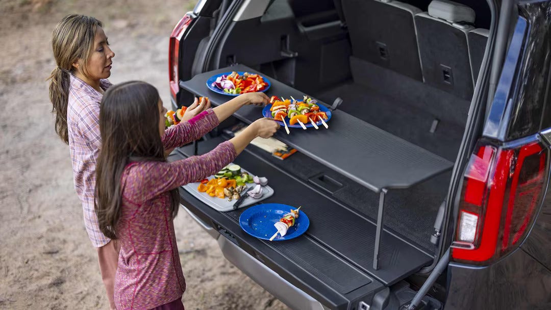 a child getting food from the tailgate of an suv