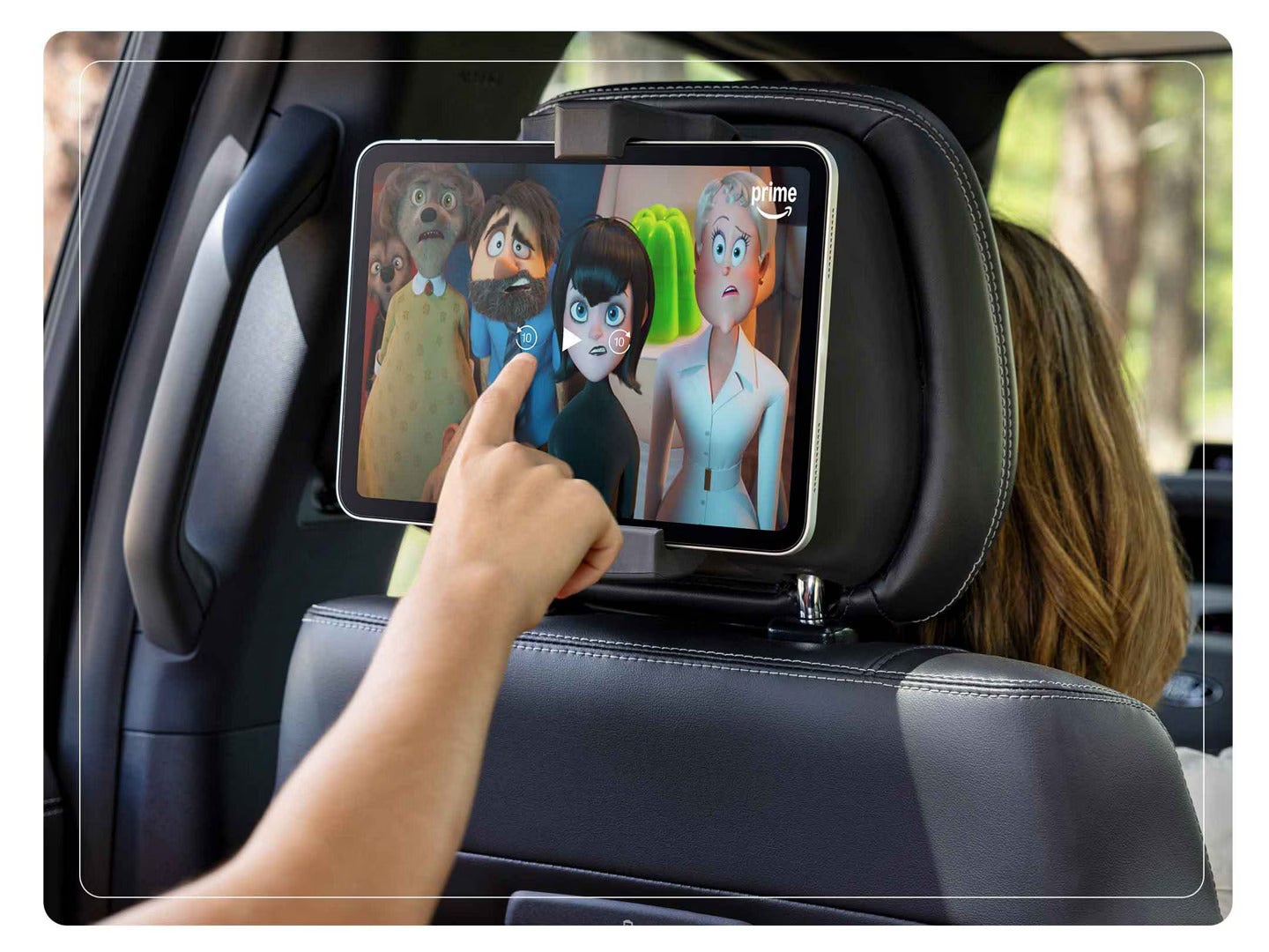a child watching a movie with a tablet attached to the back of the headrest in an suv