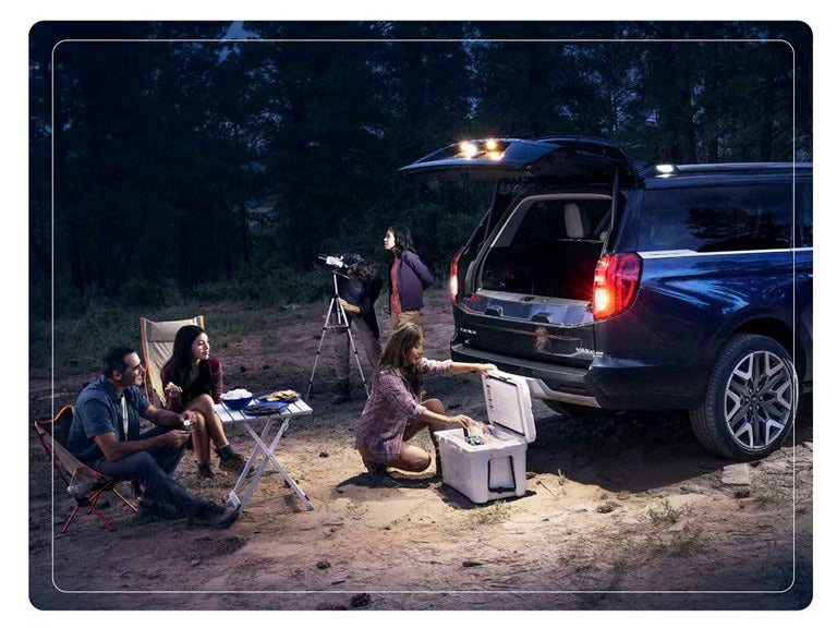 a blue ford expedition set up for camping with campers at night in the woods