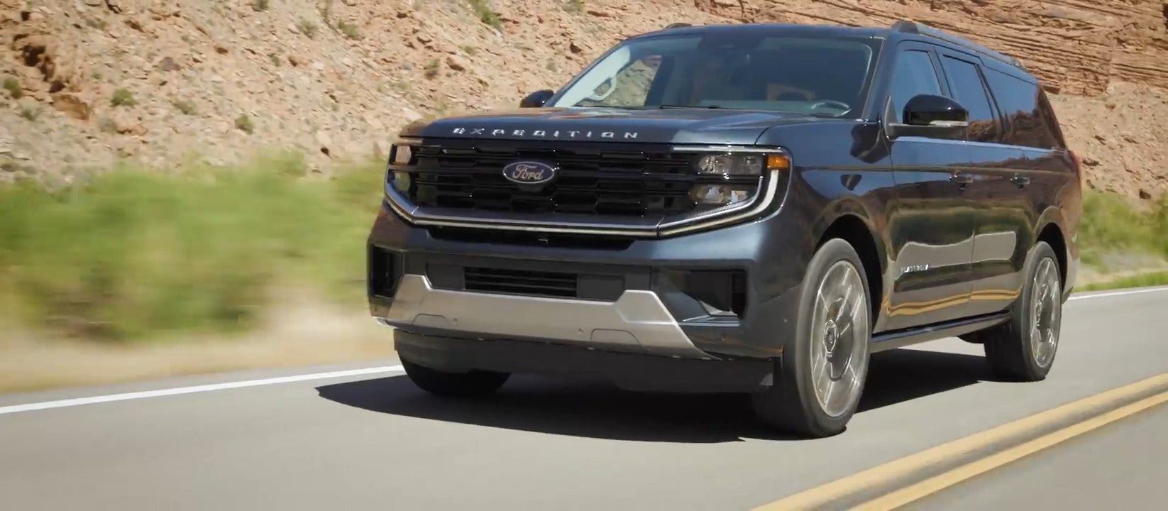 a ford full sized suv driving on a winding highway