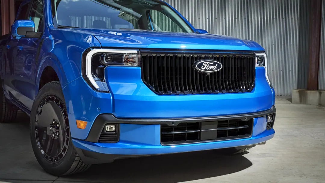a blue ford maverick showcasing the close up of the front grille and LED headlights
